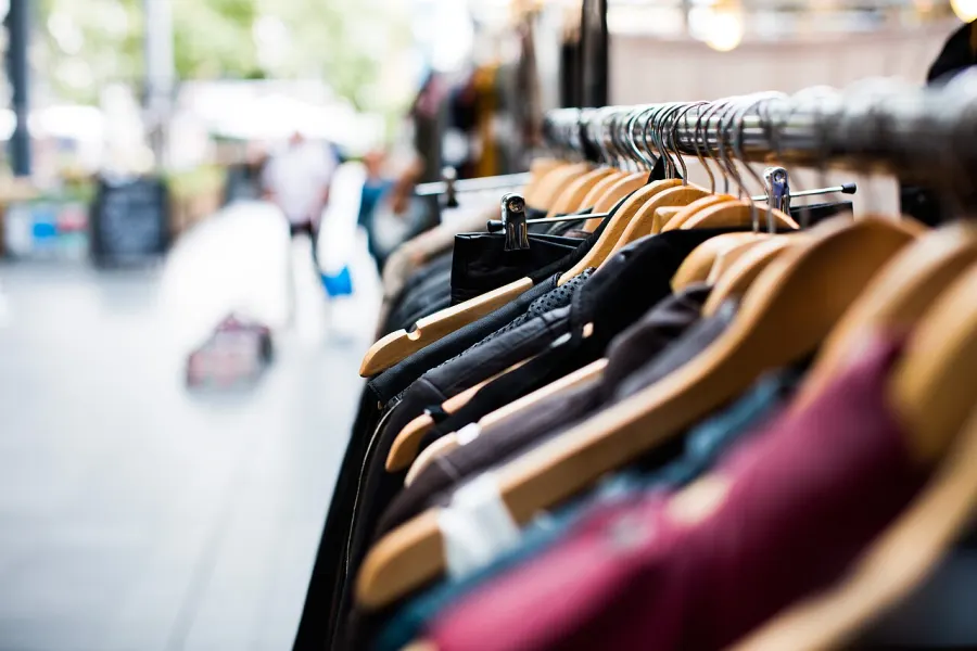 Portant de vêtements colorés sur cintres en bois